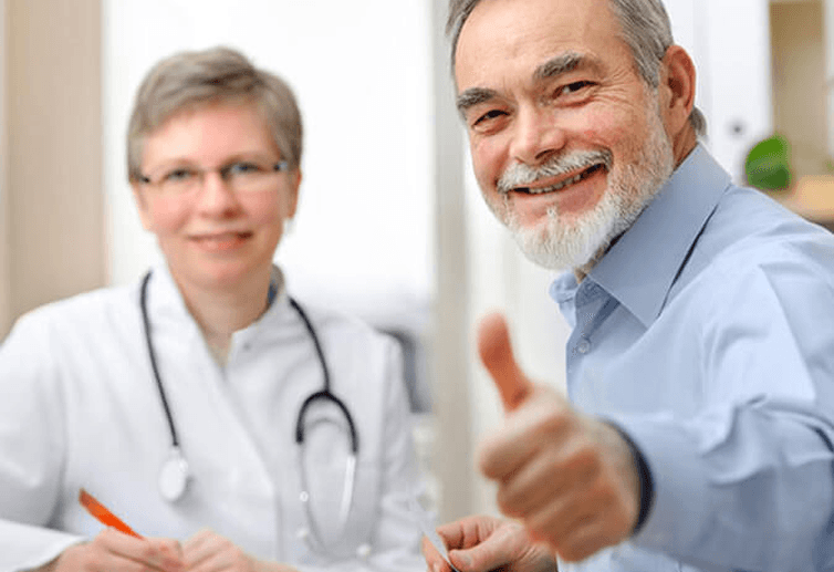 Smiling patient giving thumbs up beside a doctor